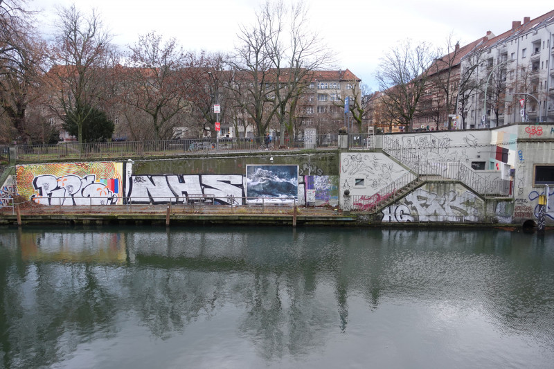Ansicht des Posters mit Wellen von Astrid Busch an der Wand der Anlage bei der Kunstbrücke