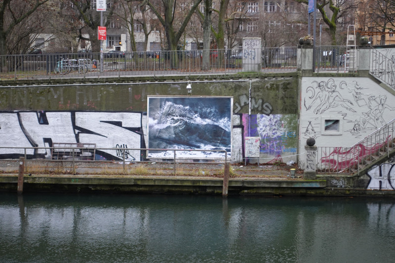 View of the poster with waves by Astrid Busch on the wall of the installation by the art bridge.