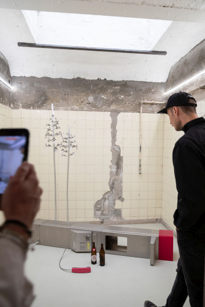 Galeriebesucher schaut sich eine Installation an, die auf dem Boden liegt