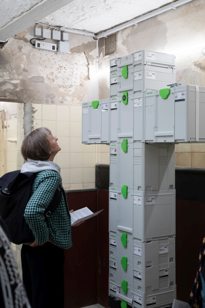 Eine Frau schaut sich eine Installation bestehend aus Kisten an
