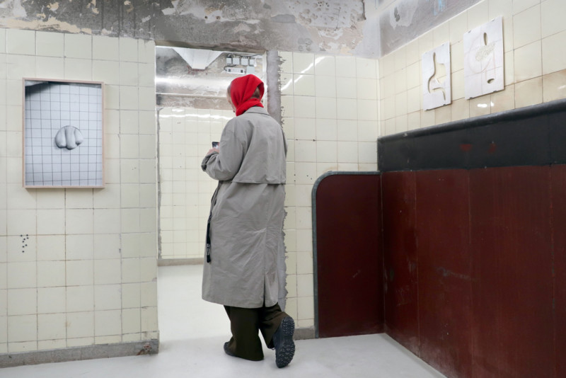 text: >
  Person in grauem Mantel und roter Mütze
  läuft durch die Ausstellung
decorative: false
source: reviewed