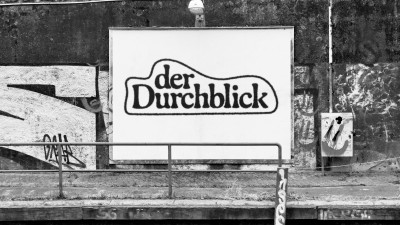 Ein schwarz-weiß Bild der Plakatwand an der Kunstbrücke am Wildenbruch mit dem Text 