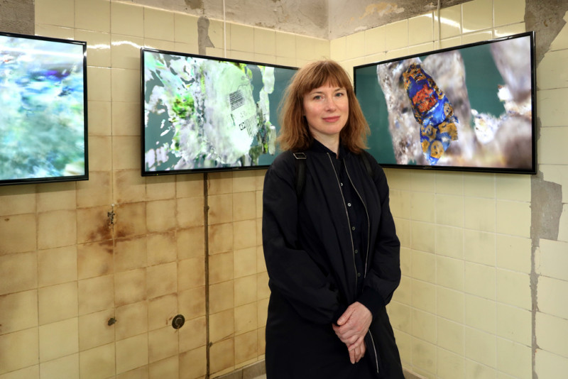 The artist Marcelina Wellmer stands in front of her latest video works: Monster, Goldessa and Capri from the year 2024.