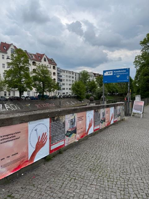 Mehrere Protestplakate hängen nebeneinander auf der Wand an der Kunstbrücke am Wildenbruch