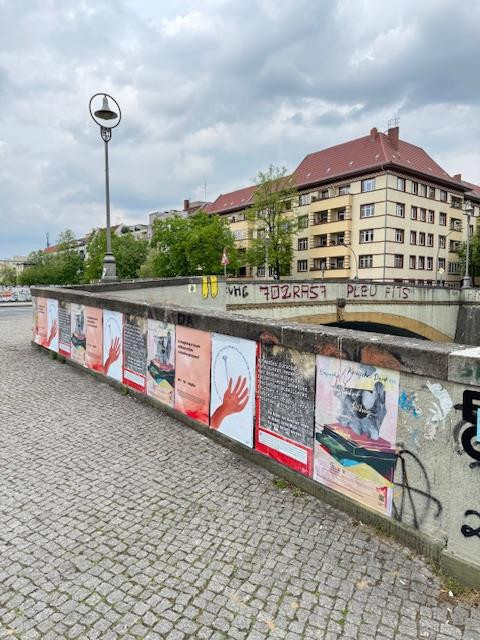 Mehrere Protestplakate hängen nebeneinander auf der Wand an der Kunstbrücke am Wildenbruch