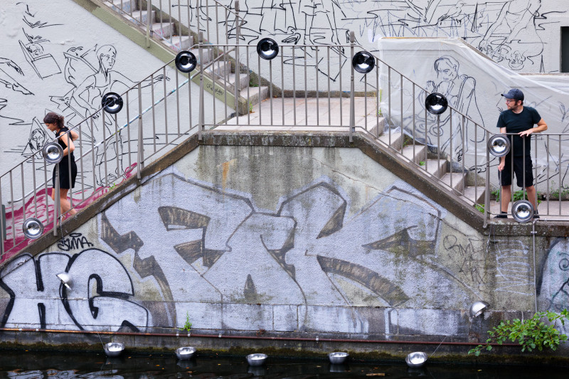 Am Treppengeländer der Kunstbrücke am Wildenbruch sind silber Schüsseln befestigt.