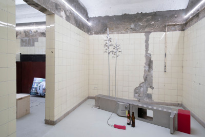 Installation aus Telefonzelle mit Bierflaschen und Videoarbeit im Nebenraum