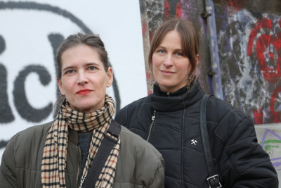 Die Zwei Künstlerinnen stehen vor der Plakatwand an der Anlegestelle