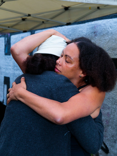 the performer embraces a person.