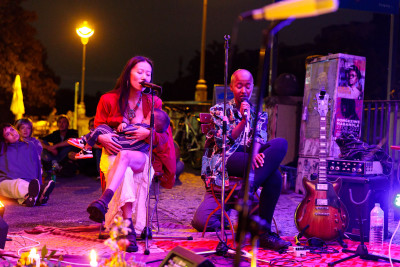 Two artist of the jam session sing. One of the artists is breastfeeding her child