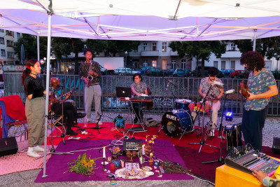 Jamsession. In front of the artists, objects, candles and  flowers lie in the middle.