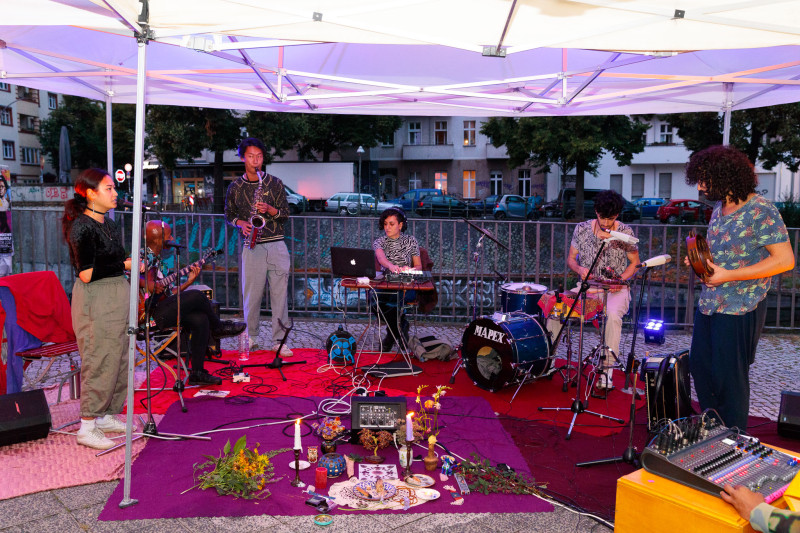 Jamsession. Vor den Künstler, liegt in der Mitte einige Gegenstände, Kerzen und Blumen.