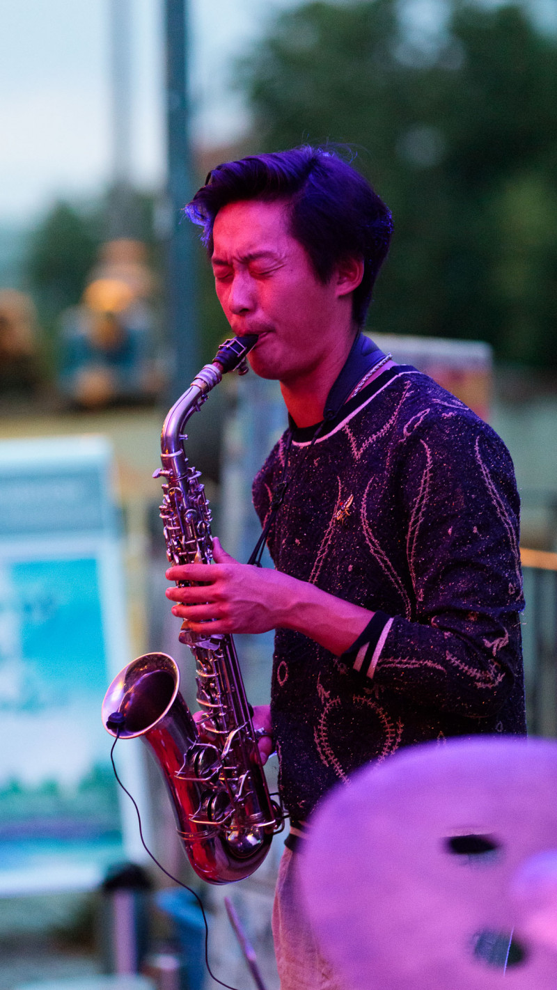 A musician of the jam session plays his wind instrument.