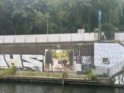 View of the Billboard of the gallery from the other side of the canalt mir einer Frau und einer Kuh.